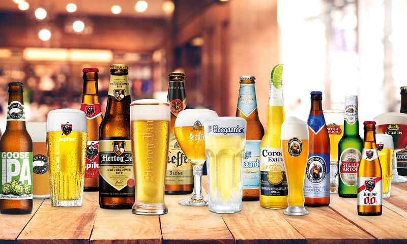 Verschillende merken bier van AB InBev naast elkaar op een houten tafel